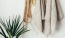 towels hanging on a wall near a plant